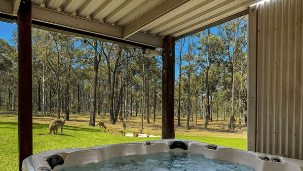 A hot tub with a view of a forest and kangaroos. - Highwoods Cottage - Authentic charm in the heart of Wine Country (Pokolbin)