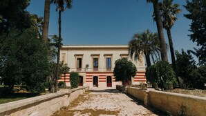 A building with a symmetrical facade, large windows, and a central entrance. - Villa Gloria (Monteroni di Lecce)
