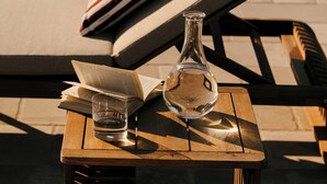 A lounge area with a table, a book, a glass, and a bottle. - Villa Gloria (Monteroni di Lecce)
