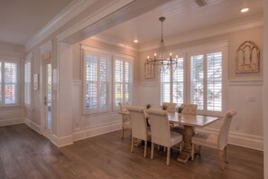 A dining room with a wooden table, six chairs, and a chandelier. - Coconut Cove by AvantStay | Deck w/ Hot Tub, Access to 2 Pools (Santa Rosa Beach)