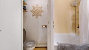 Een badkamer met toilet, douche en een handdoekhouder.