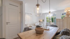Ein Essbereich mit einem Holztisch, gewebten Körben und Blick ins Freie.