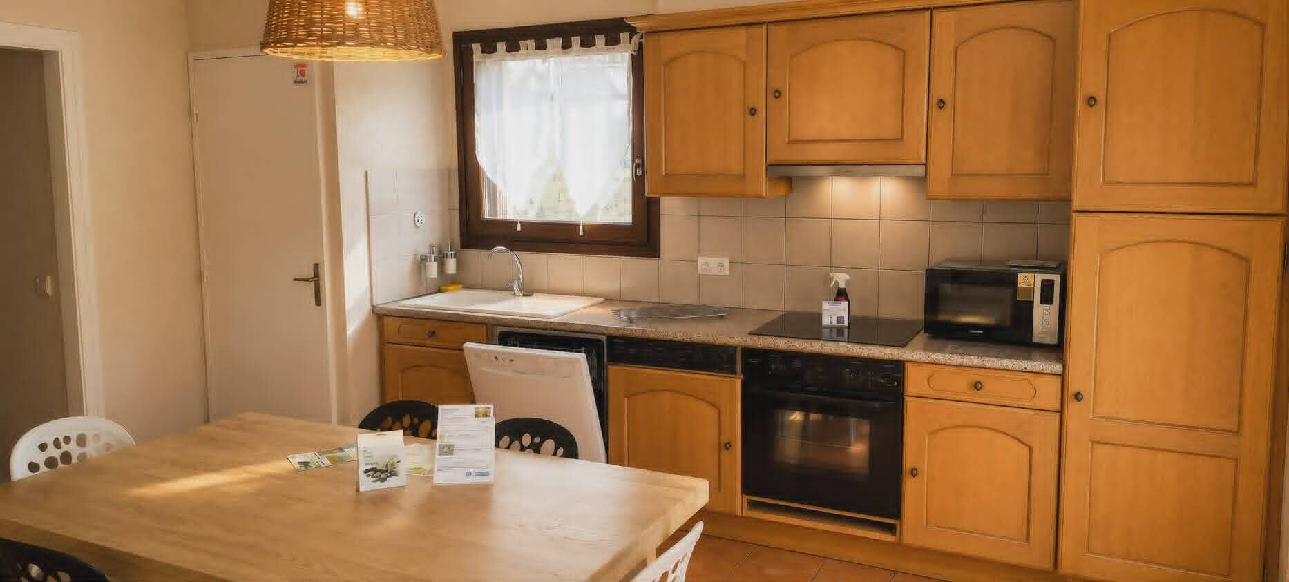A compact kitchen with wooden cabinets, a sink, a microwave, and a dishwasher.