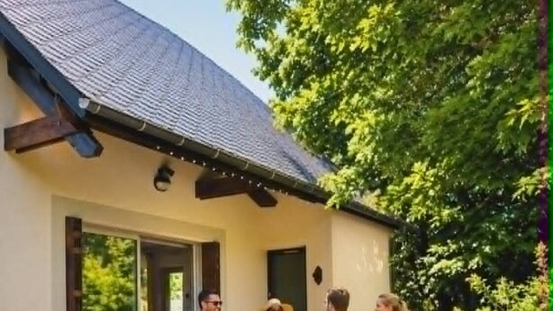 Eine Terrasse im Freien mit Grill, Tisch und Stühlen.