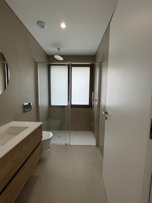 Ein modernes Badezimmer mit Dusche, Toilette und Waschtisch.