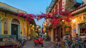 A narrow street with buildings on either side, bicycles parked along the sides, and a red scooter in the center. - Studio 4 Kalamata - Bright Escape in the Centre (Kalamata)