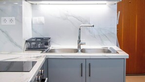 A modern kitchen with a built-in oven, a sink, and cabinets. - Studio 4 Kalamata - Bright Escape in the Centre (Kalamata)