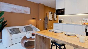 Una cocina moderna con armarios blancos, una isla de madera y un comedor.