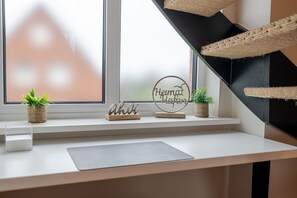 A window sill with two potted plants, a wooden block with letters, and a circular sign with text. - Dolles Hüs - Dolles Hüs – Stylish family vacation home with a garden in (Wenningstedt-Braderup (Sylt))