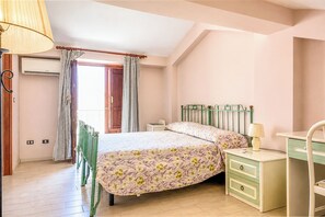 Una camera da letto con un letto, una scrivania, una sedia e una lampada.