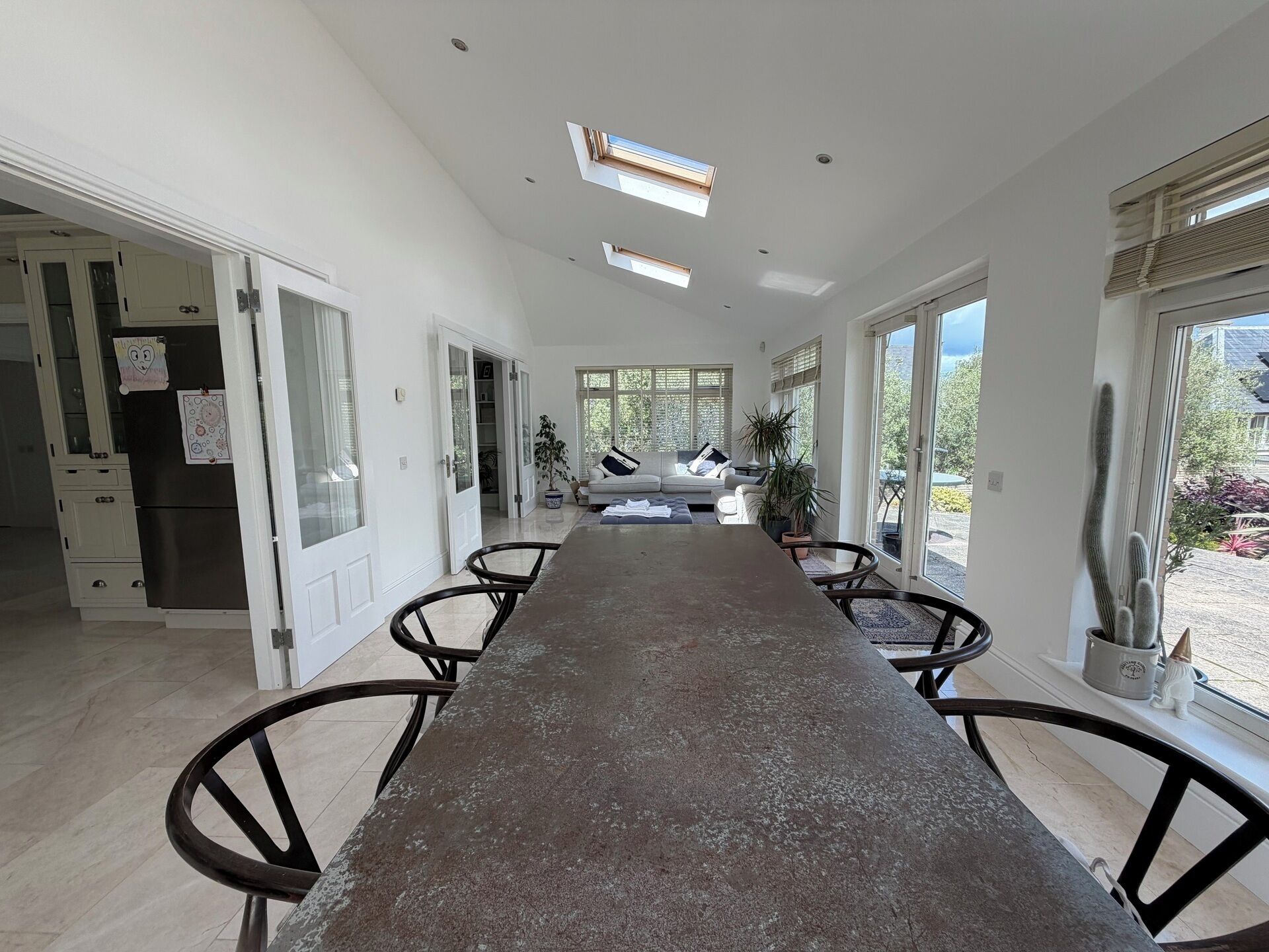 A spacious kitchen with a long counter, modern appliances, and large windows.