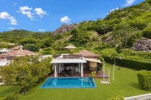 A modern house with a swimming pool, patio, and mountain backdrop. - KUMO 2BR Ocean View Pool - Rooftop (Tambon Hua Hin)