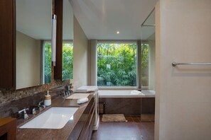A modern bathroom with a large window, a bathtub, a double sink, and a mirror. - KUMO 2BR Ocean View Pool - Rooftop (Tambon Hua Hin)