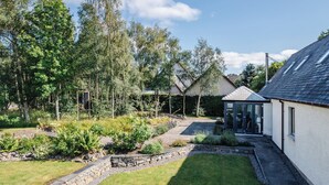 A residential property with a garden, a small shed, and a house with a sloped roof.