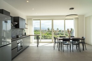 A modern kitchen with a dining area, large windows, and a view of the outdoors. - Family d'Orlando Apartments (Capo d'Orlando)