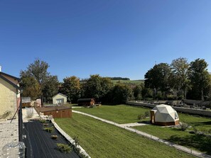 Une propriété située en zone rurale, comprenant une grande pelouse, une grange et une petite maison.