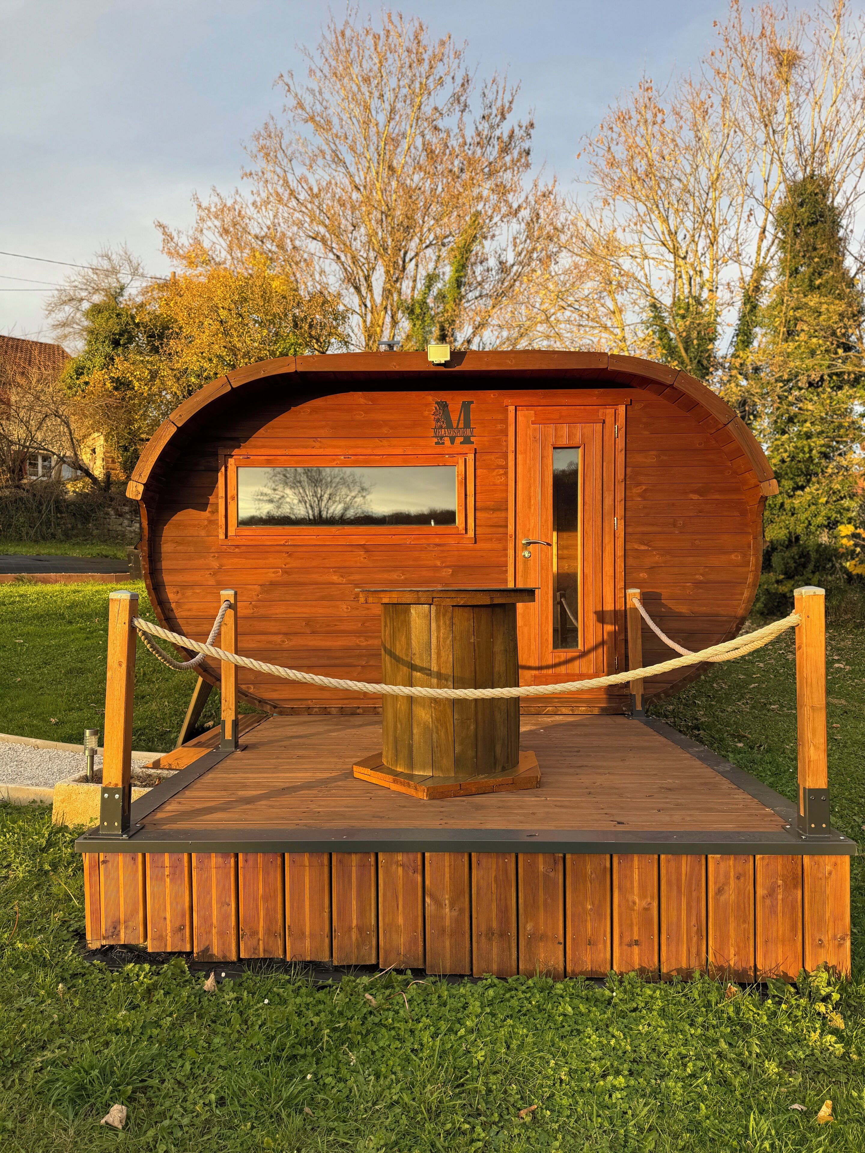 A wooden cabin with a door, a window, and a rope barrier.