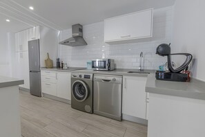 Una cucina moderna con elettrodomestici in acciaio inox, forno a microonde integrato e lavastoviglie.