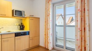 A compact kitchen with a microwave, kettle, and Bosch dishwasher. - Doppelhammer Apartment House (Bad Füssing)