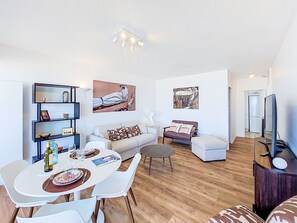 A modern living room with a dining area, a sofa set, a coffee table, and a flat-screen TV. - Apartment Joigny by Interhome (Arcachon)