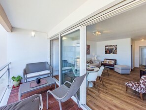 Een modern appartement met balkon, eethoek en woonkamer.