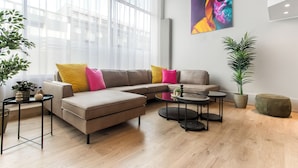 A modern living room with a sectional sofa, a coffee table, and a potted plant.