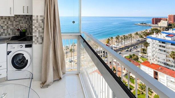 A balcony with a view of the sea, a washing machine, and a glass table. - Beachfront, 12th Floor with Stunning Views, Maite 2, Benalmádena (Benalmádena)