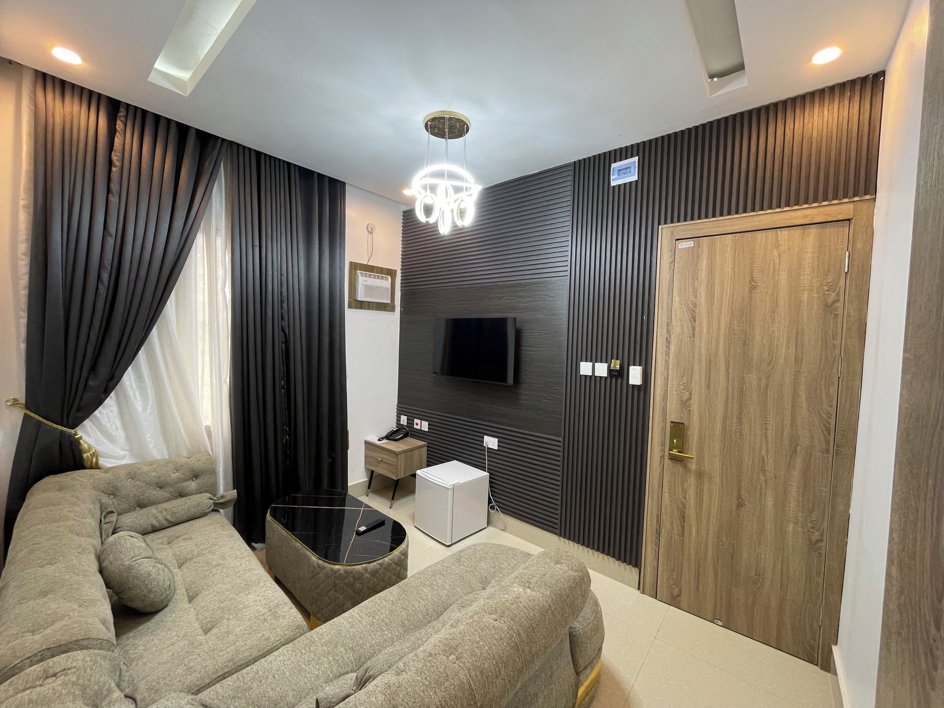 Una camera da letto moderna con un letto, comodini, una TV e una porta in legno.