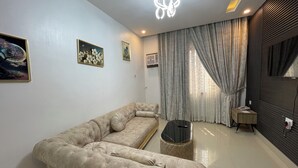 A modern living room with a sofa, a coffee table, and a TV.