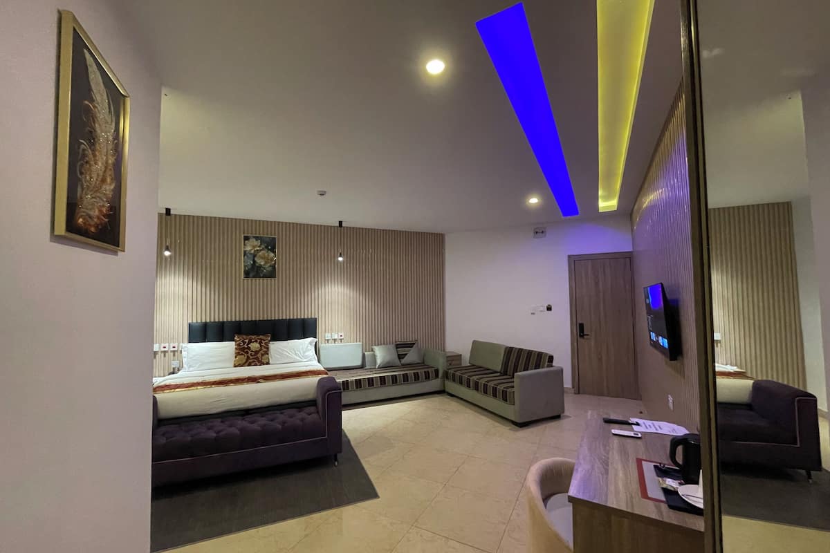 Une chambre d’hôtel moderne équipée d’un lit, d’un canapé, d’un bureau et d’une télévision.