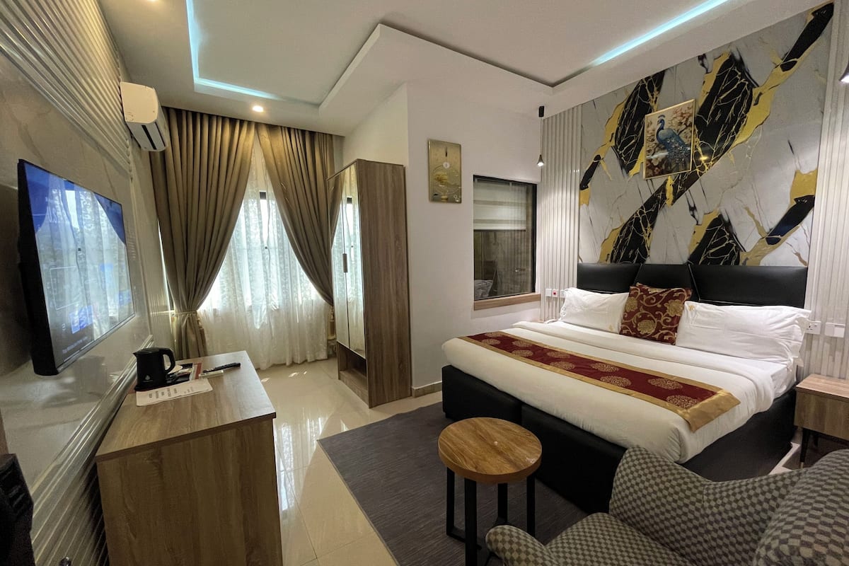 Une chambre d’hôtel moderne équipée d’un grand lit, d’un bureau, d’une télévision et d’un coin salon.