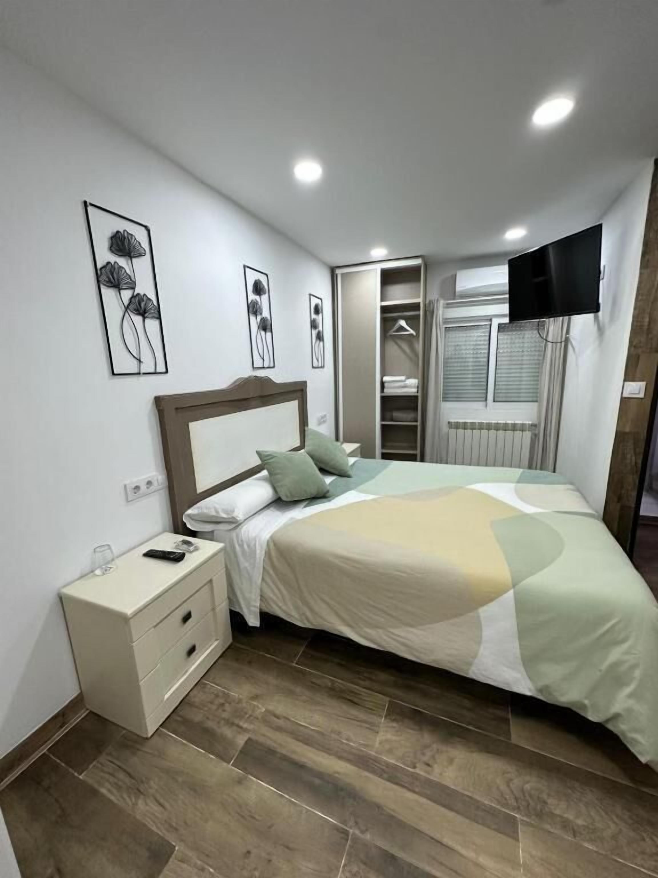 A bedroom with a bed, nightstand, and a walk-in closet.