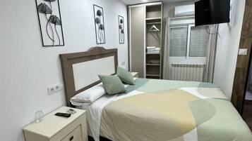 A bedroom with a bed, nightstand, and a walk-in closet.