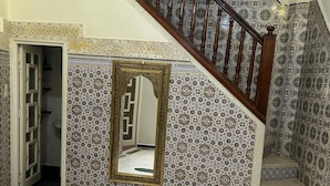 A staircase with patterned tiles, a mirror, and a geometric floor design. - Entire apartment, in the medina, rooftop, 7-minute walk from the Oudayas and the beaches. (Rabat)