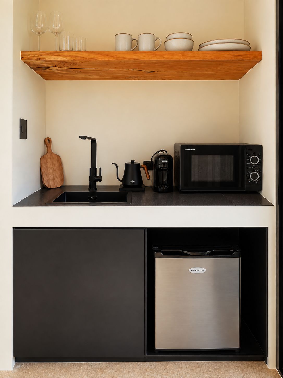 A compact kitchen with a microwave, coffee maker, and a refrigerator.
