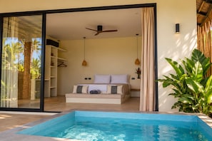 A bedroom with a bed, a ceiling fan, and a view of a swimming pool. - SIROCO VILLAS (San Juan)