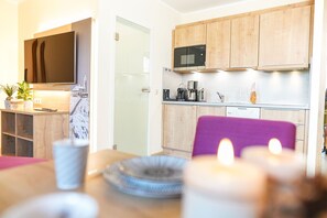 A modern kitchen with wooden cabinets, a microwave, and a coffee maker. - Simon's Vacation Rental 7 - Stylish, modern, and with a magnificent view (Oberwiesenthal)