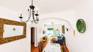 Un comedor con una mesa larga, sillas y una lámpara de araña.