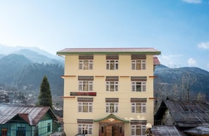 A multi-story building with a traditional architectural style, featuring a flat roof and multiple windows. - Verdant The Vintage (Lachung)
