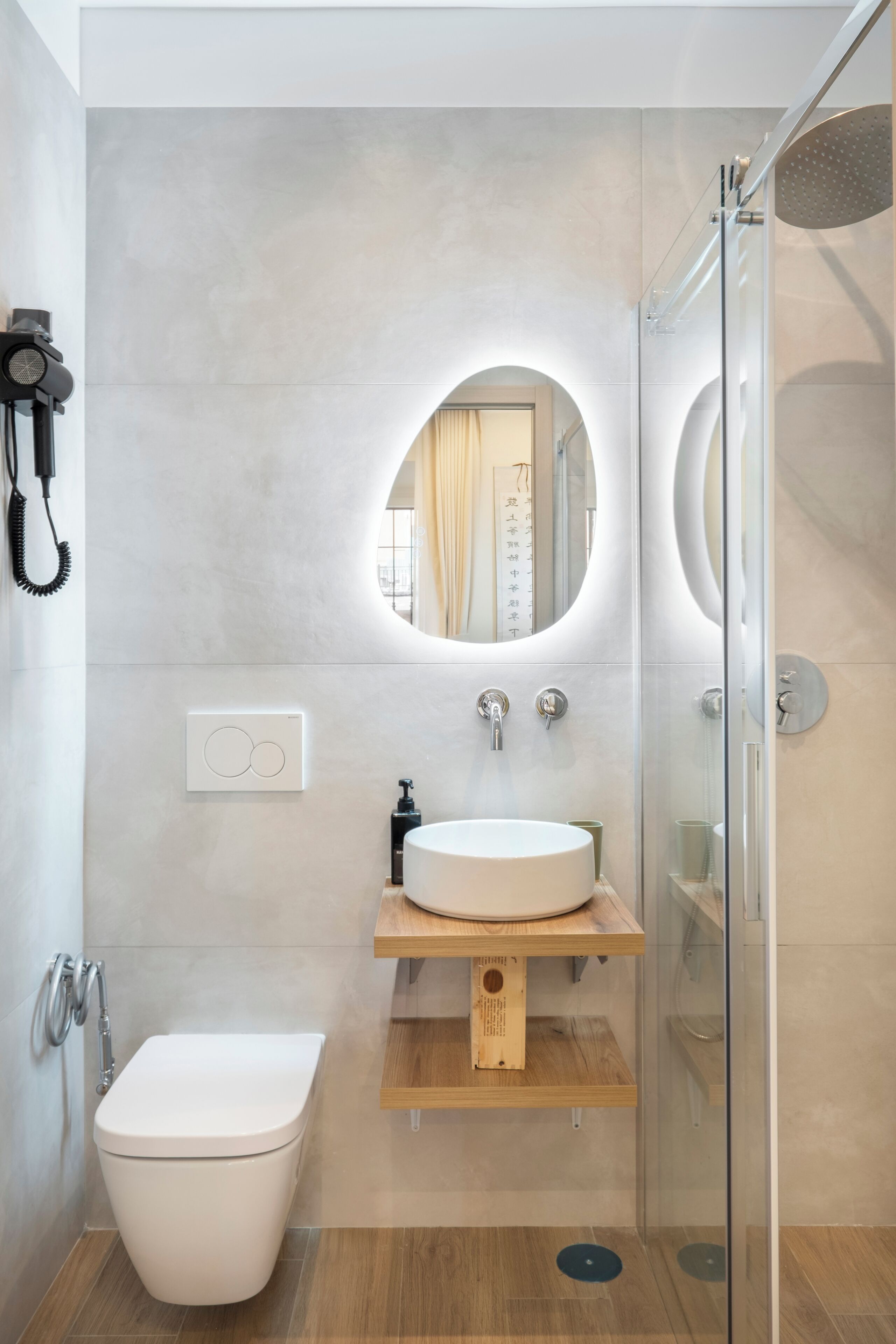 A modern bathroom with a toilet, sink, and shower.