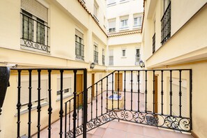 A multi-level building with balconies, a central courtyard, and a staircase with ornate railings. - (PRA100C) 2 bedroom and 2 bathroom apartment in the center of Madrid (Madrid)