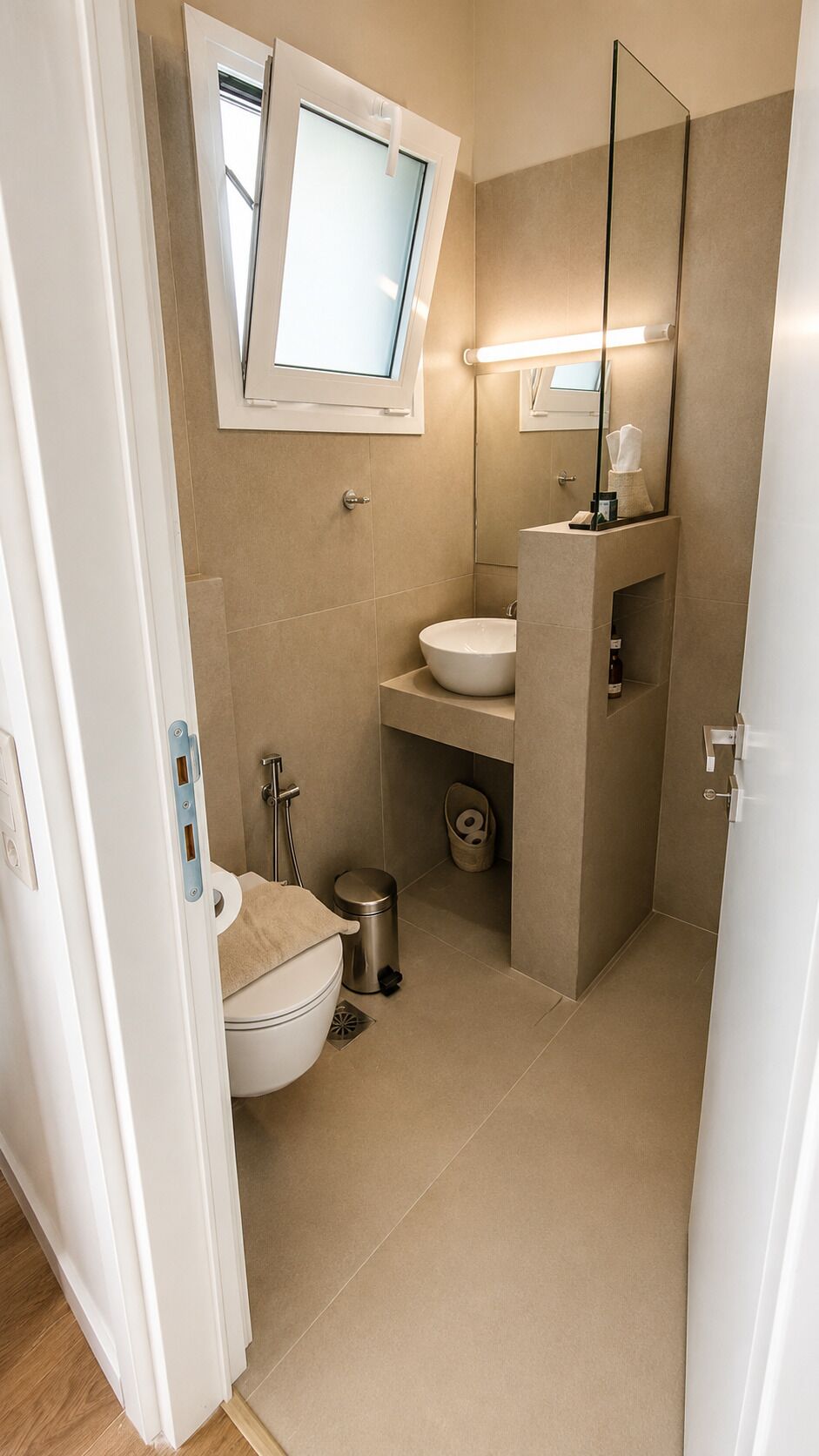 A bathroom with a toilet, sink, and mirror.