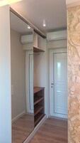 Una habitación con armario de puerta corredera, una puerta blanca y una pared de piedra.