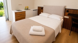 A bedroom with a bed, bedside table, and a window.