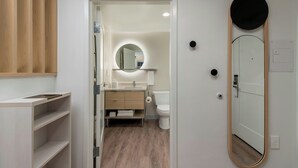 Un baño moderno con lavamanos integrado, espejo y retrete.