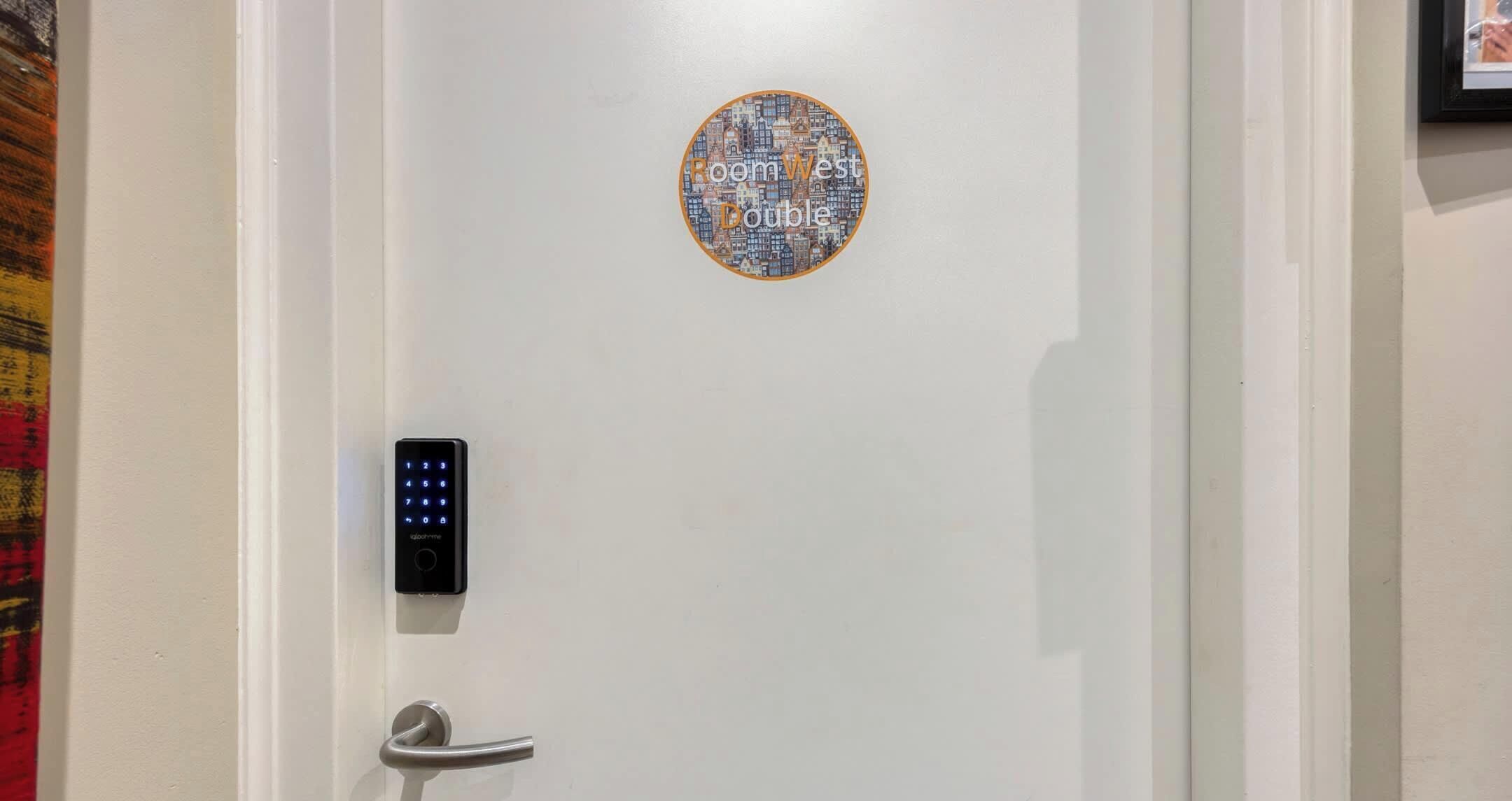 Een deur met een digitaal slot en een ronde decoratie erboven.