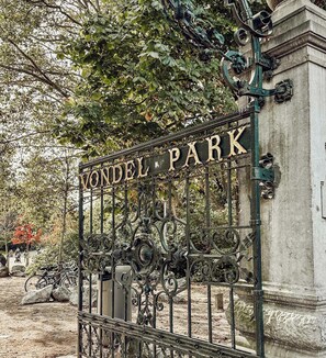 Una reja de hierro forjado con la inscripción 'VONDEL PARK' en un parque.