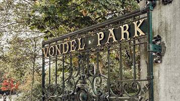 Een ijzeren poort met de tekst 'VONDEL PARK' in een park.
