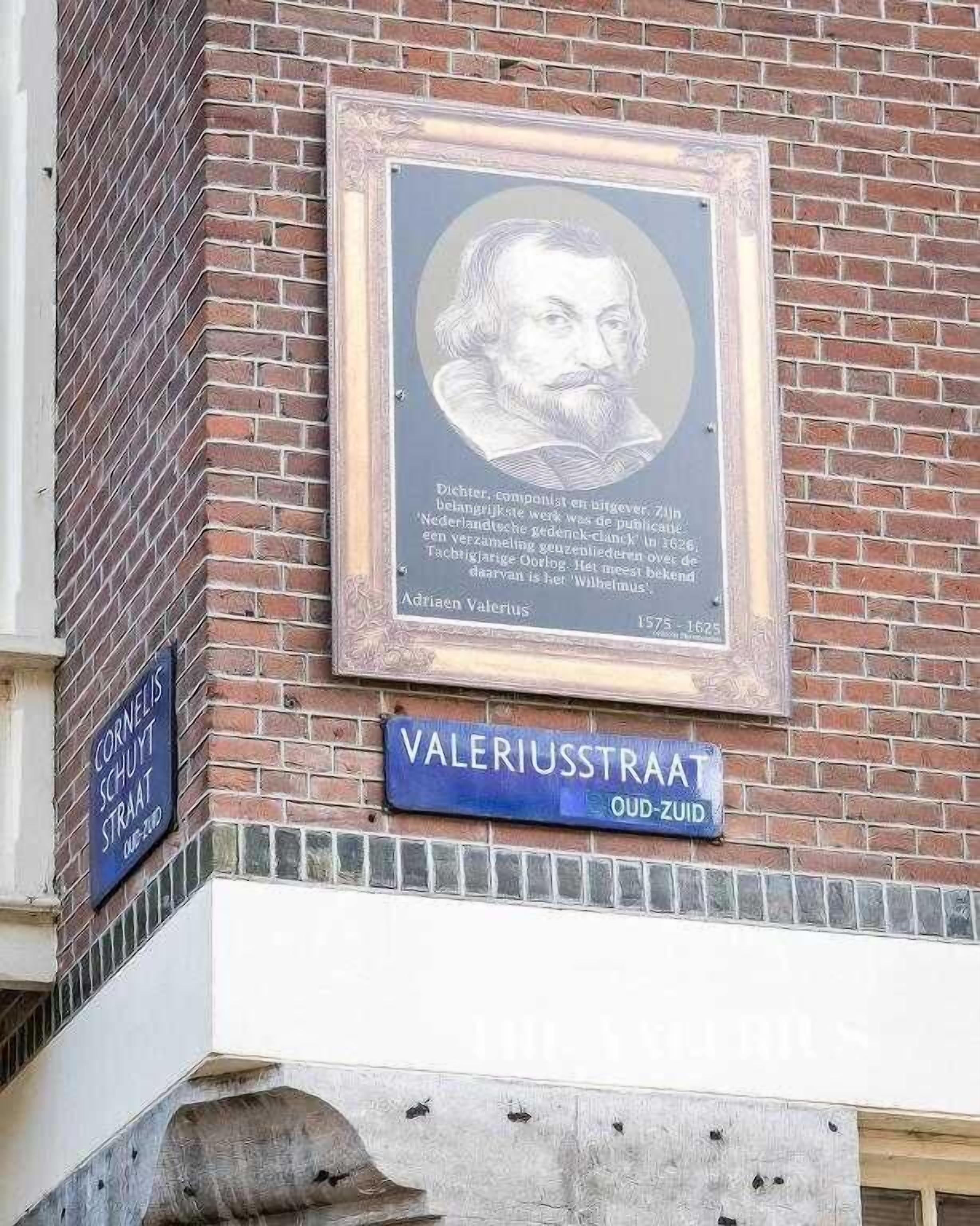 Un edificio de ladrillo con un retrato enmarcado y una señal de calle.