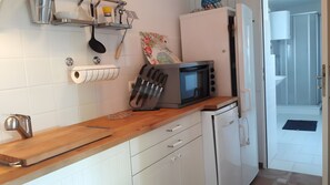 A kitchen with a microwave, knife set, and a roll of paper towels. - Holiday Home 'Italian Flair in Spandau' with Private Terrace & Garden (Berlin)